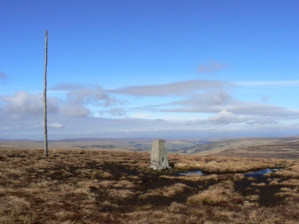 The trig point and wooden pole on the top of Killhope Law